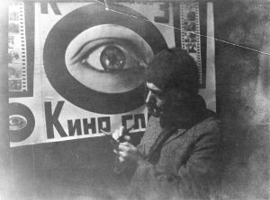 Vertov vor einem Plakat zu "Kinoglaz"