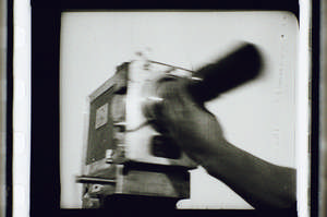 Kaufman schraubt Objektiv auf die Kamera, schneller Schwenk