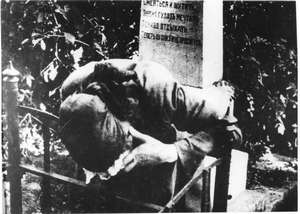 Alte Frau trauert am Grab