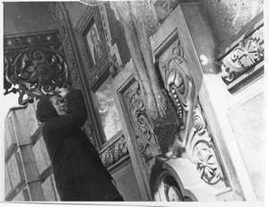 Alte Frau betet am Kreuz