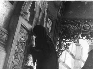 Alte Frau küsst das Kreuz