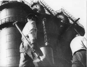 Arbeiter gehen an Türmen vorbei