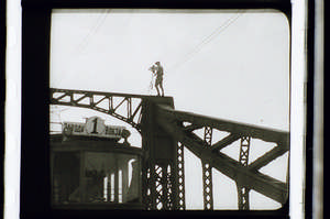Kaufman steht mit Kamera auf der Brücke