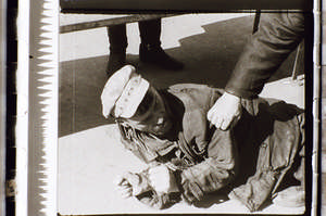 Betrunkener am Boden mit Kappe