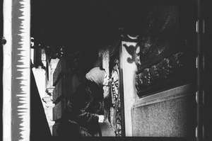 Frau im Pelzmantel küsst das Kreuz