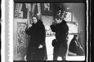 Mann und Frau bekreuzigen sich beim Kreuz